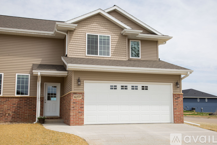A house with a garage and a white door is available for purchase.