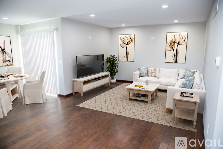 A living room with a white couch, a coffee table, and a television.