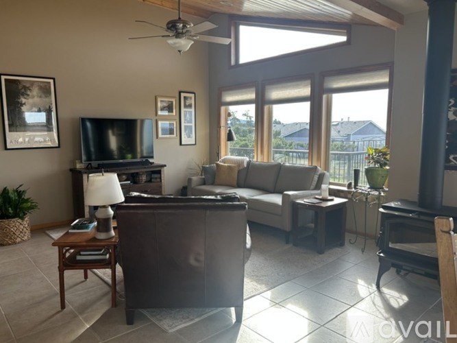 A living room with a television, couch, and a fireplace.