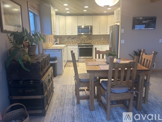 A kitchen with a dining table and chairs.