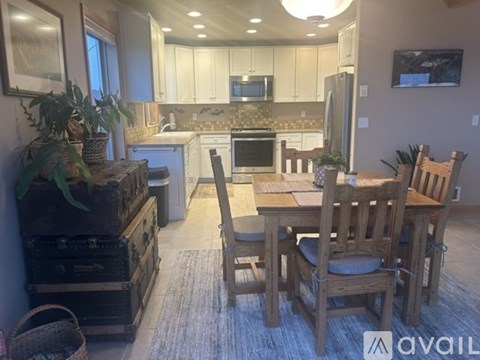A kitchen with a dining table and chairs.