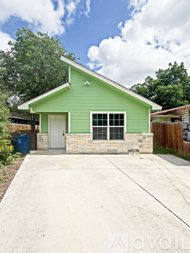 A green house with a white door and windows.