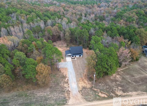 A house is surrounded by trees in the image.
