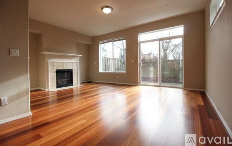 A spacious living room with hardwood floors and a fireplace.