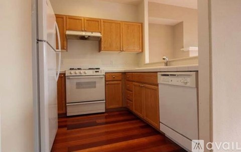 A kitchen with wooden cabinets and white appliances.