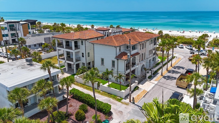 A beachfront apartment complex with a clear blue sky above.