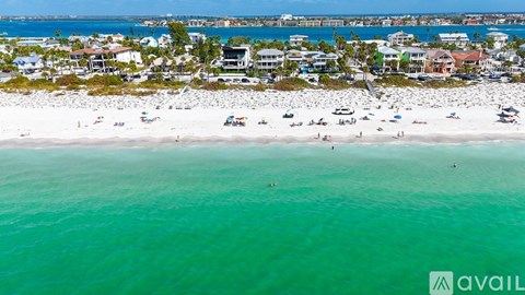 A beach with people and buildings in the distance.