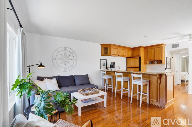 A living room with a couch, a table, and a plant.