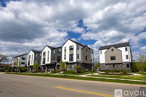 A row of modern houses with a cloudy sky in the background.