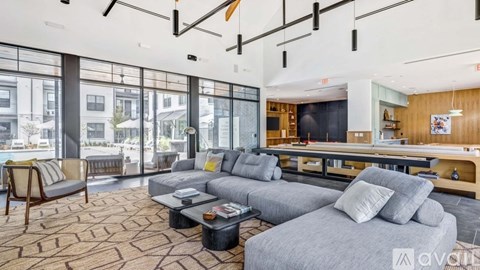 A living room with a grey couch and a wooden chair.