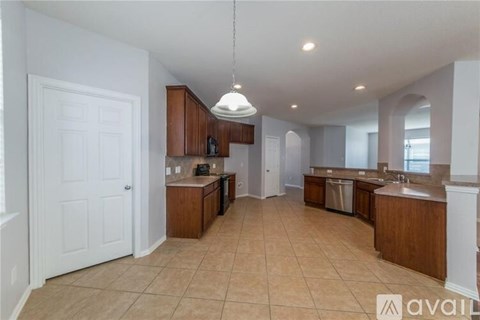 A kitchen with brown cabinets and a white door.
