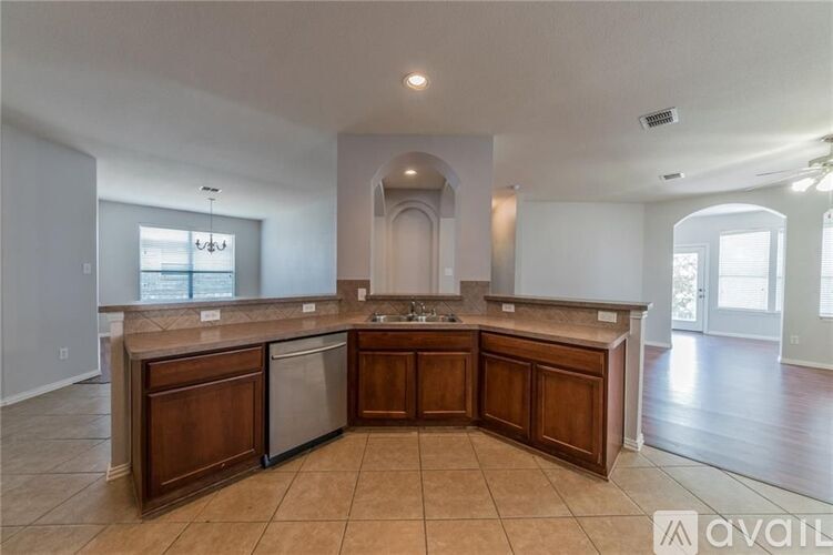 A kitchen with a large island and wooden cabinets.