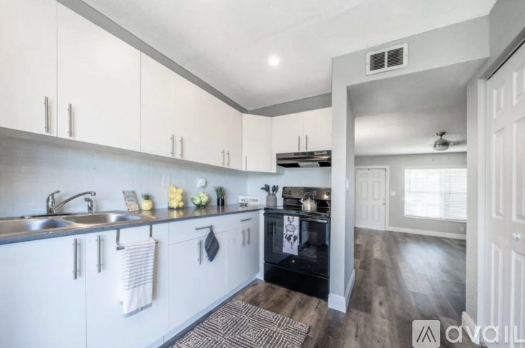 A modern kitchen with white cabinets and a black oven.