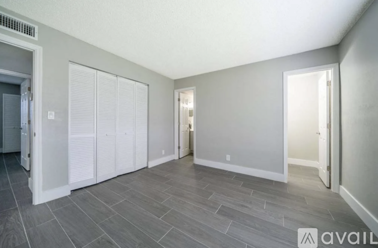 A spacious room with grey flooring and white walls.