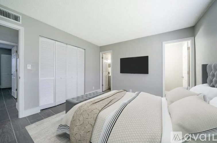 A bedroom with a large bed and a flat screen TV mounted on the wall.