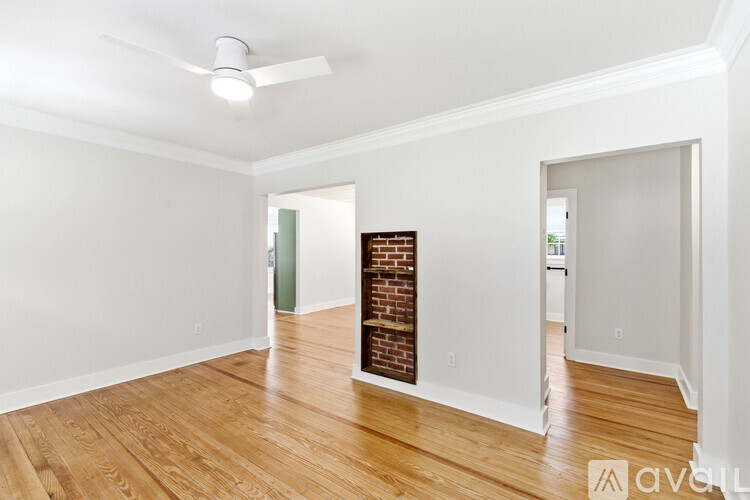 A room with a brick fireplace and wooden floors.