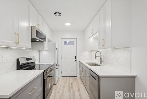 A modern kitchen with white cabinets and a marble countertop.
