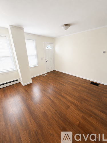 A room with wooden flooring and a door.