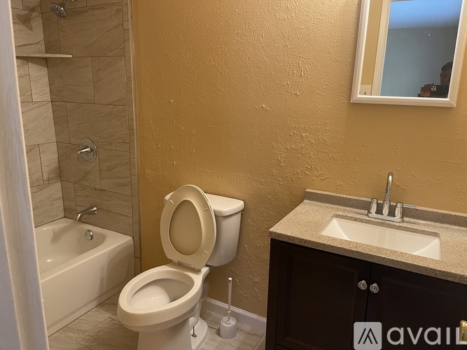 A bathroom with a toilet, sink, and bathtub.