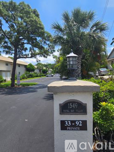 A white pillar with the number 1549 on it stands in front of a house.