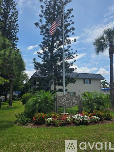 A house with a sign in front of it and a flag on a pole.