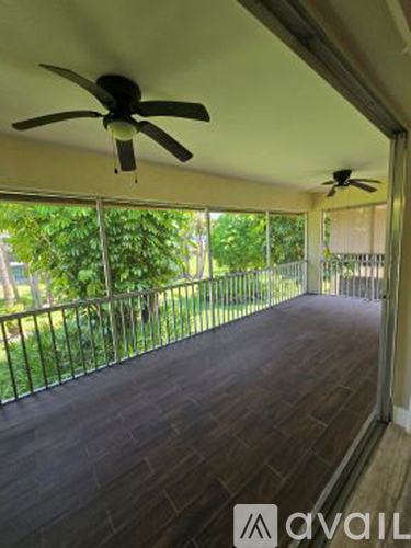 A patio with a ceiling fan and a railing.