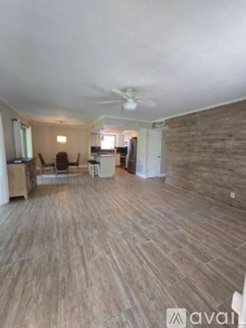 A living room with a wooden floor and a ceiling fan.