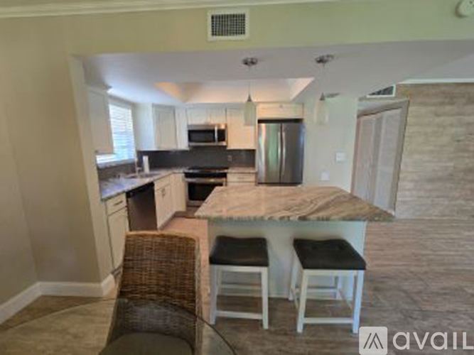 A kitchen with a table and chairs in front of it.