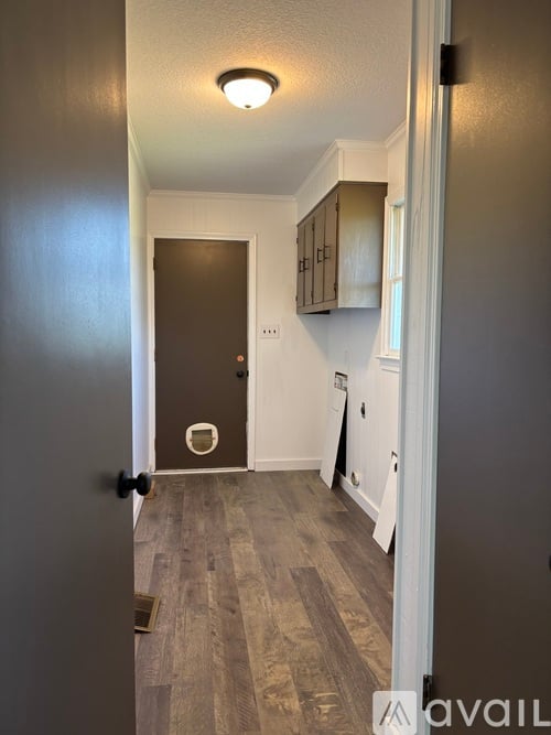 A hallway with a black door and a white door.