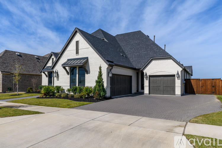 A large house with a grey roof and a black garage door.