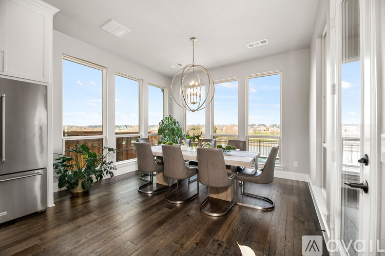 A modern kitchen with a dining table and chairs.