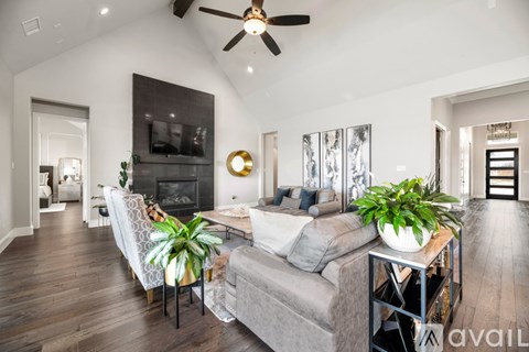 A living room with a grey couch and a wooden floor.