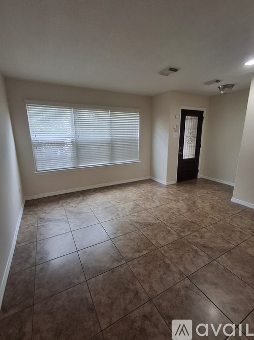A room with tiled flooring and a door.