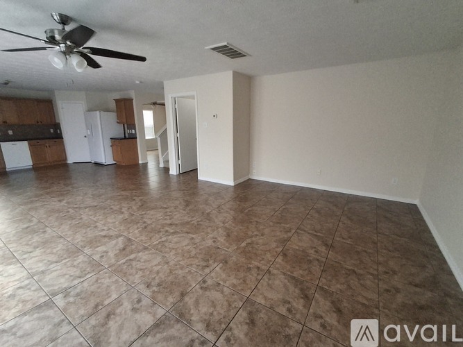 A spacious room with a ceiling fan and tile flooring.