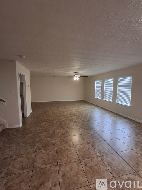 A room with tile flooring and a ceiling fan.