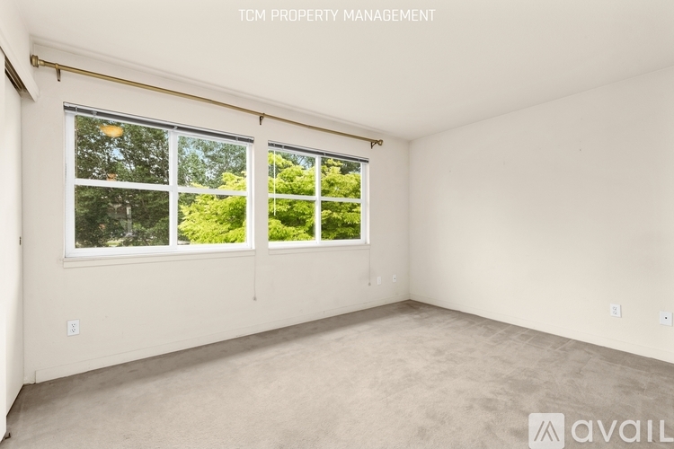 A room with a large window and a view of trees outside.