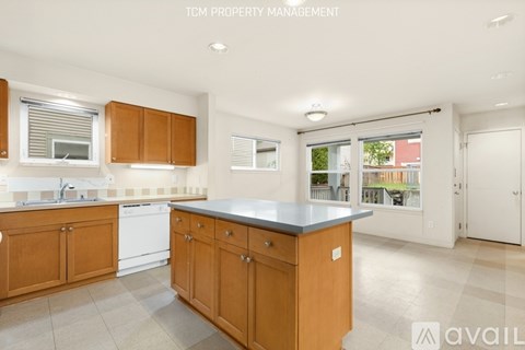 A kitchen with wooden cabinets and a large island.