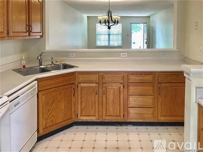 A kitchen with wooden cabinets and a white dishwasher.
