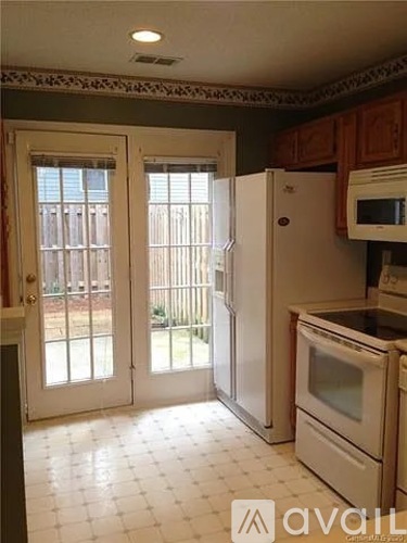 A kitchen with a white fridge and a white tiled floor.