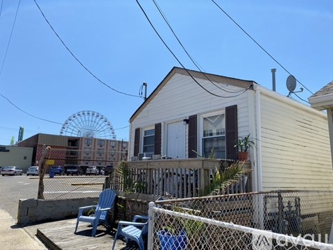 A small white house with a blue chair in front of it.