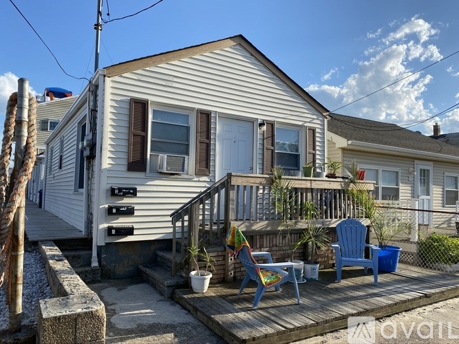 A small house with a porch and a blue chair.