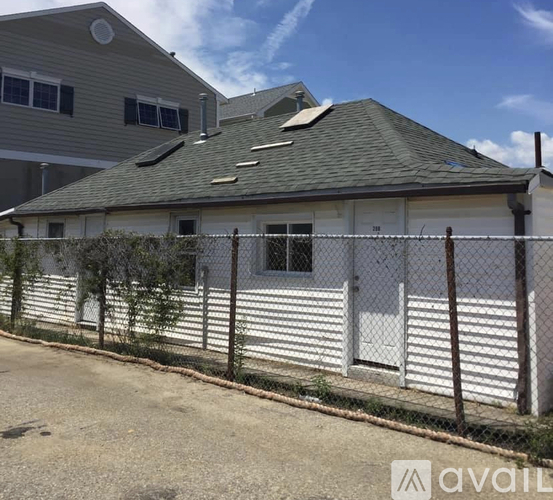 A house with a grey roof and a white fence.