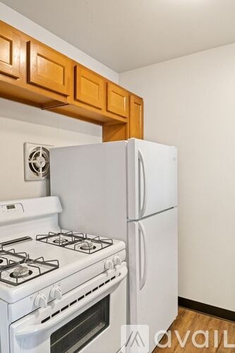 A kitchen with a white stove and refrigerator.