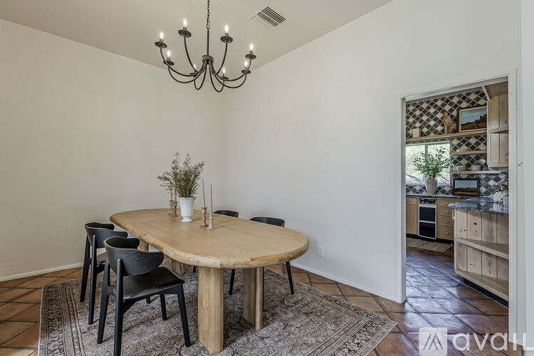 A dining room with a round wooden table and chairs.