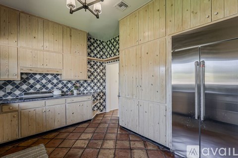 A kitchen with wooden cabinets and a checkered backsplash.