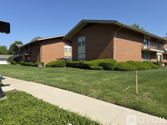 A brick building with a green lawn in front.