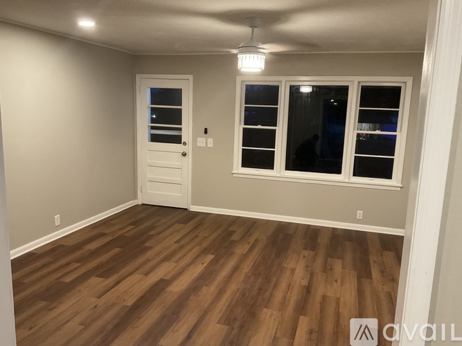 A room with wooden flooring and a white door.