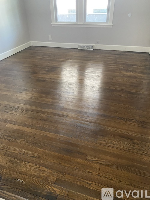 A room with a wooden floor and a window.