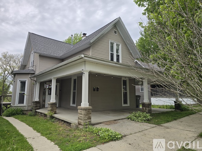 A house with a grey roof and a porch.