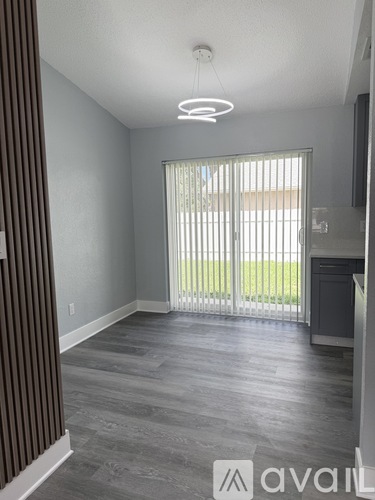 A room with a sliding glass door leading to a balcony.